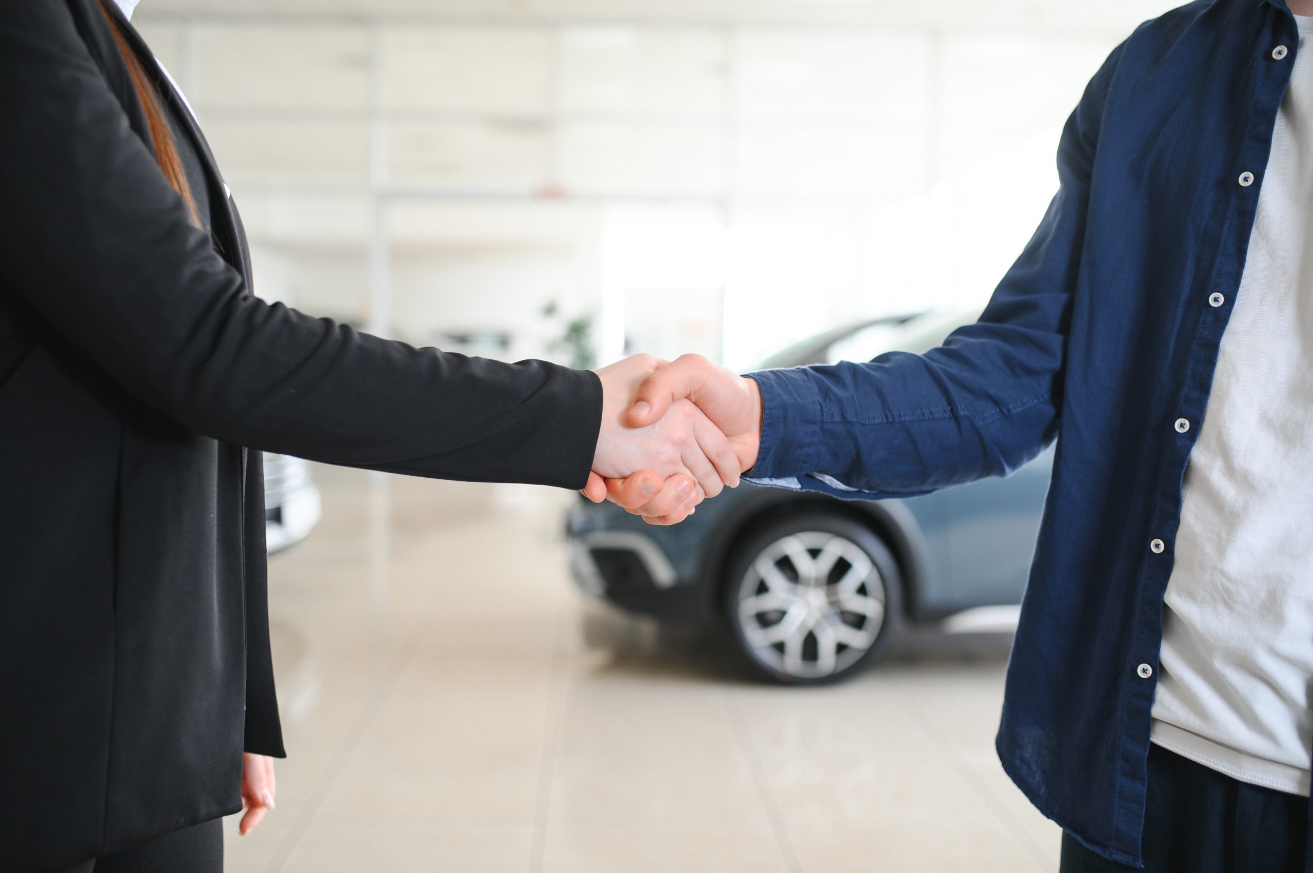 Woman shaking hands with car salesperson