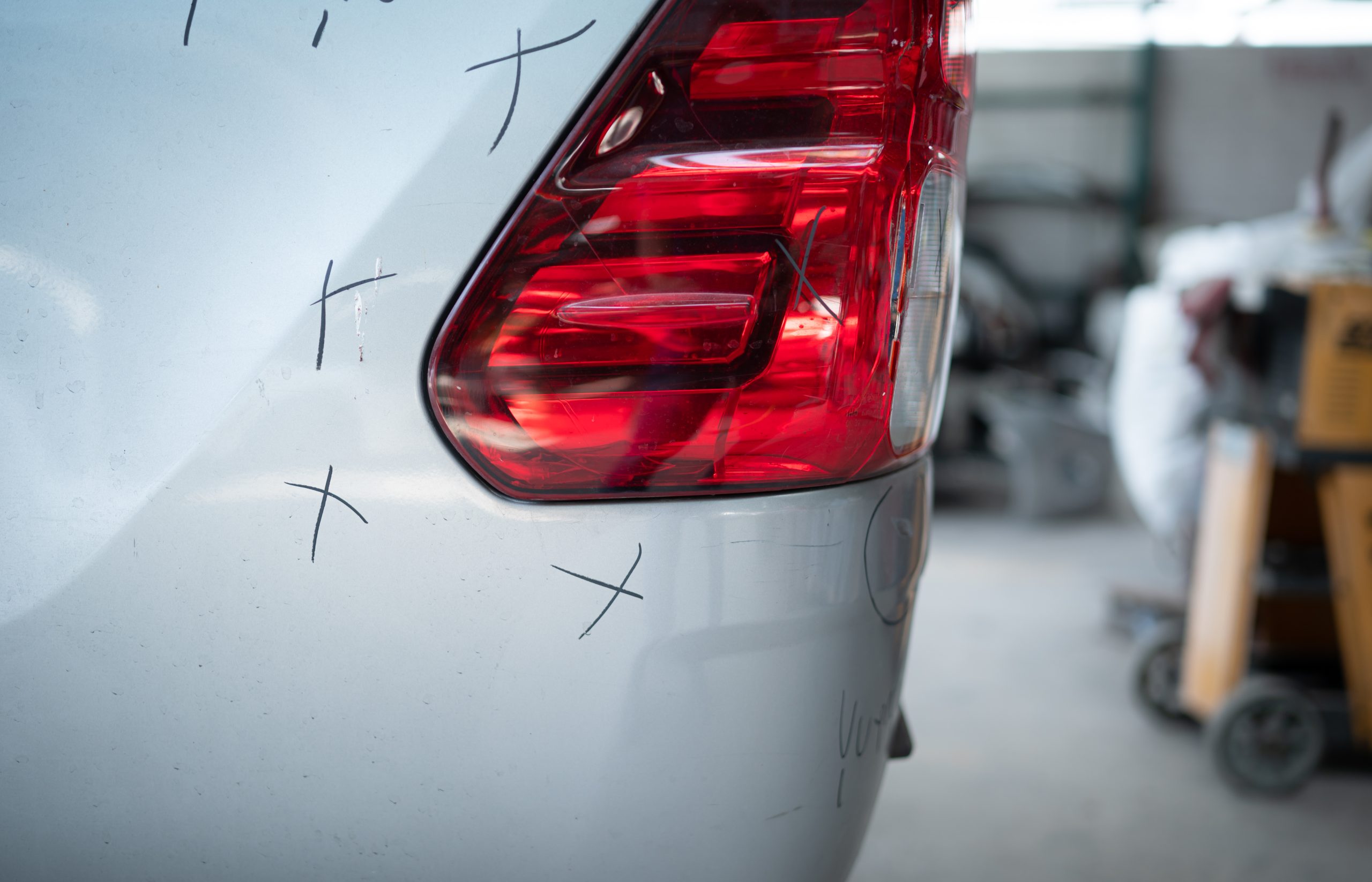 A car mechanic checks the condition of a car body to be repaired