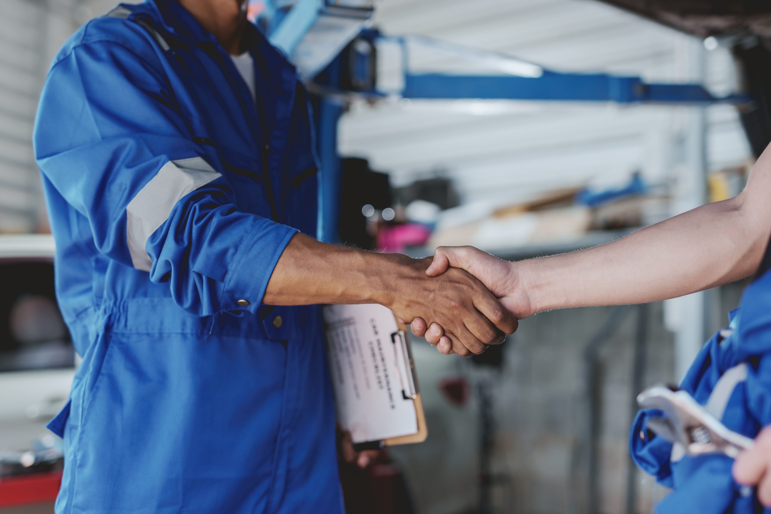Auto mechanic handshake successful colleague in auto service cen